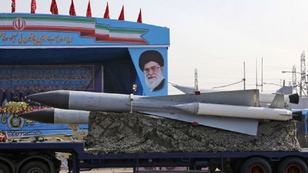 2018年的伊朗建军日阅兵上，载着导弹的军用卡车驶过伊朗最高领导人哈梅内伊的头像。（图源：法新社）.jpg