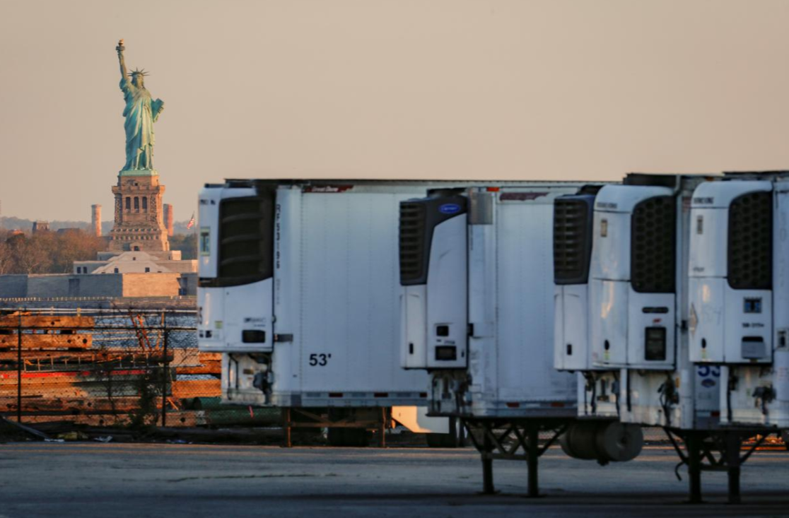 纽约市布鲁克林区，自由女神像与用于存放新冠患者遗体的冷藏拖车。（图源：路透社）.png